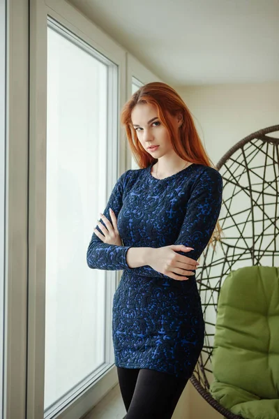 Retrato de una hermosa joven con el pelo rojo cerca de la ventana —  Fotos de Stock