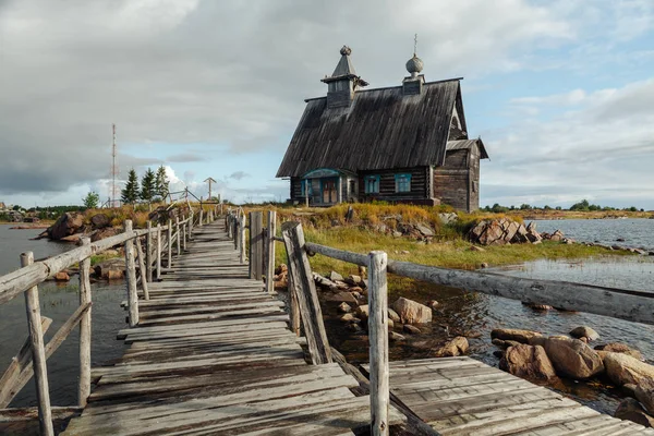 Old russian Orthodox wooden church in the village Rabocheostrovsk, Karelia. Abandoned church on the coastline. — Stock Photo, Image