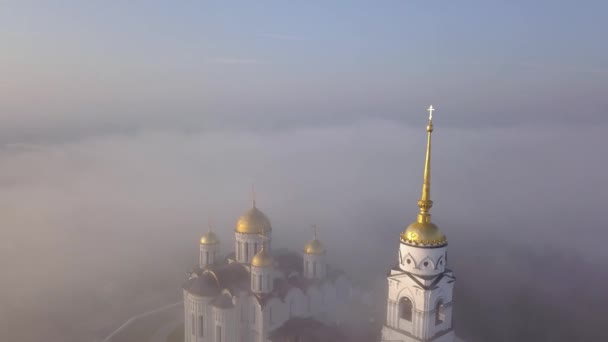 Mistige ochtend op de kathedraal van de veronderstelling in Vladimir. Wolken mist vliegen over de kathedraal. Birds eye view. — Stockvideo