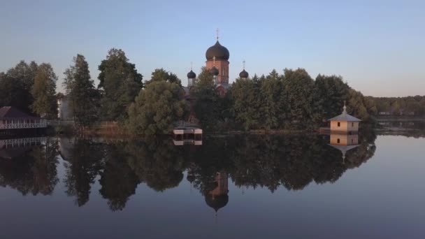 Klasztor Świętego-Wwiedienski w Rosji. Na wyspie. Widok z lotu ptaka. Lot nad wodą z klasztoru. Refleksje po jeziorze. — Wideo stockowe