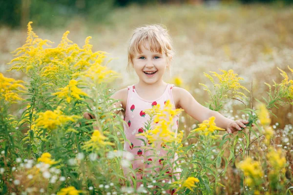 Menina doce em um prado com flores selvagens da primavera — Fotografia de Stock