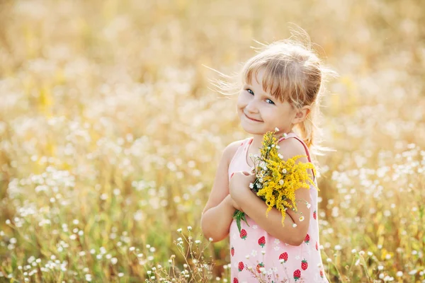 Menina doce em um prado com flores selvagens da primavera — Fotografia de Stock