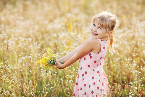 Menina doce em um prado com flores selvagens da primavera — Fotografia de Stock