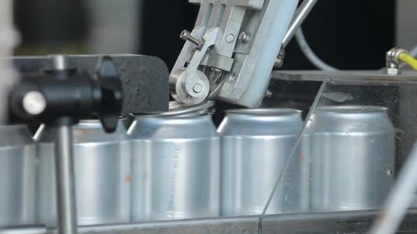 Transportador para llenar latas de aluminio. Los bancos se mueven a lo largo del transportador y la máquina cierra las tapas de las latas — Vídeos de Stock