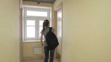 Bir sırt çantası ile genç bir kız otel koridor yürür ve odasına girer.