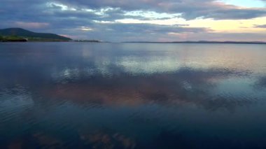 Akşam bulutlar deniz yüzeyindeki yansımasıdır. Su üstünde dron yayılımı. Gün batımında güzel Kuzey Doğa.