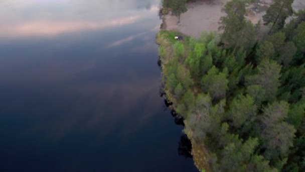 Spännvidd av Drönaren längs kusten i havsbukten. Skogen på stranden. Norra landskap. — Stockvideo