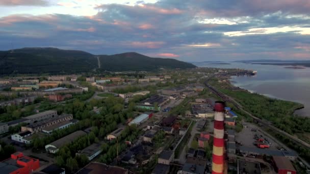 Vliegende drone over een typische noordelijke Sovjet-stad. Fabrieken, pijpen, stad blokken en heuvels op de achtergrond. — Stockvideo