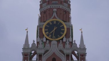 Kırmızı meydanda Spasskaya Kulesi 'nde, gri bulutlu bir günde kasvetli bir gökyüzünde saat. Yakın çekim