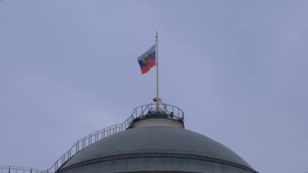 Ρωσική σημαία στο παλάτι της Γερουσίας κάτω από ένα ζοφερό ουρανό σε μια γκρίζα συννεφιά στη Μόσχα Κρεμλίνο — Αρχείο Βίντεο