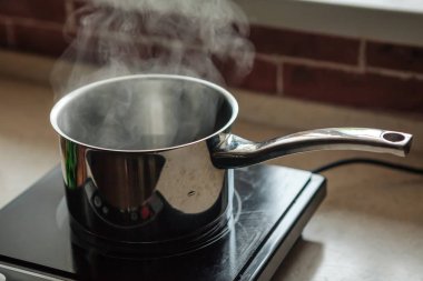 Elektrikli mutfak sobası üzerinde kaynar su ile Tencere