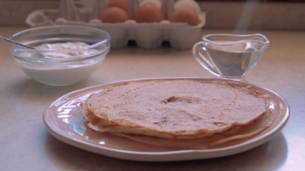 Stack av heta klassiska ryska tunna pannkakor. Rustik stil. Traditionell för den ryska pannkaka veckan-Maslenitsa. Gräddfil, smör och ägg i bakgrunden. — Stockvideo