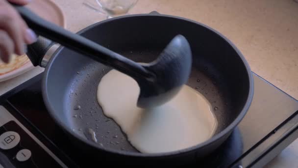 Руки наливают тесто в кастрюлю и готовят блинчики. . — стоковое видео