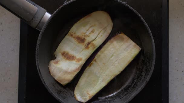 Berinjela, fatias fatiadas são fritas em manteiga em uma frigideira. Close-up, vista superior . — Vídeo de Stock