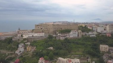 Napoli'deki Santelmo Kalesi'nin havadan görünümü. Körfez ve şehir blokları bakan kale üzerinde drone uçuş.