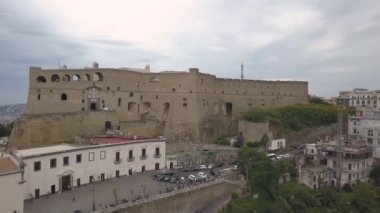 Napoli'deki Santelmo Kalesi'nin havadan görünümü. Körfez ve şehir blokları bakan kale üzerinde drone uçuş.