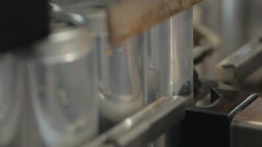 Alüminyum kantlar dolum için konveyör. Bankalar konveyör boyunca hareket eder ve makine onları bir sonraki aşamaya taşır. Yakın çekim.