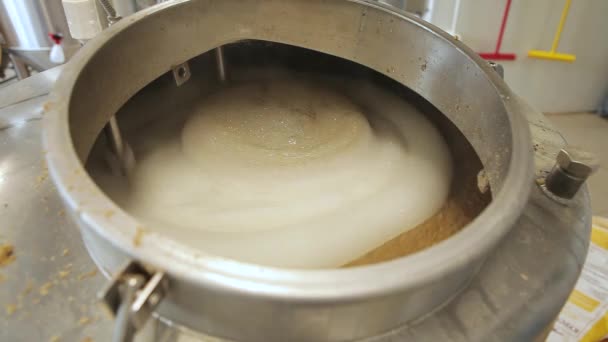 Beer is brewed and fermented in large aluminum tanks. Foam on the surface. Close-up. — Stock Video