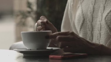 kız kahve içiyor ve telefona bakıyor, yakın çekim