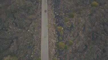 Etna Dağı'nın yamacının havadan görünümü. Arabanın seyahat ettiği yolda uçan insansız hava aracı. İtalya, Sicilya