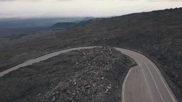 Εναέρια θέα της πλαγιάς της Αίτνας. Ιπτάμενοι κηφήνες πάνω από το δρόμο στο οποίο ταξιδεύει το αυτοκίνητο. Ιταλία, Σικελία — Αρχείο Βίντεο