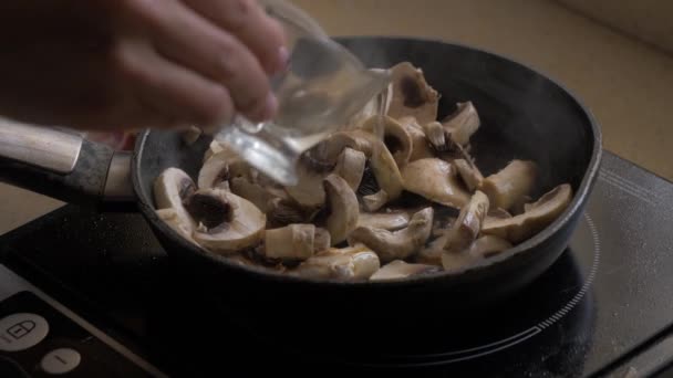 Os champinhons fritam-se em uma panela, vazam-se com o óleo e misturam-se . — Vídeo de Stock