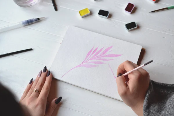 Uma Mulher Pinta Num Caderno Esboços Ferramentas Para Pintar Mesa — Fotografia de Stock