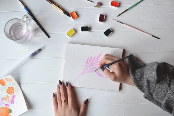 Uma Mulher Pinta Num Caderno Esboços Ferramentas Para Pintar Mesa — Fotografia de Stock