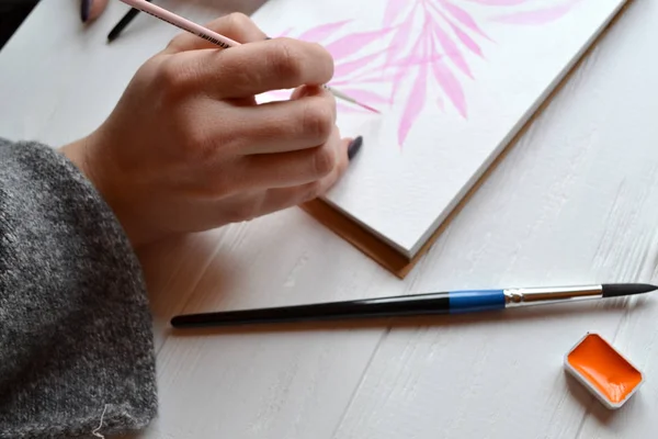 Uma Mulher Pinta Num Caderno Esboços Ferramentas Para Pintar Mesa — Fotografia de Stock