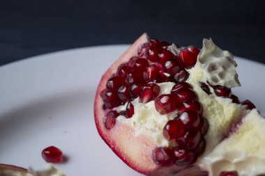 Nar beyaz tabakta. Yakın çekim.