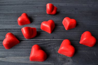 Kırmızı şeker koyu mavi ahşap arka plan üzerinde kalp şeklinde. Makro vurdu. Sevgililer günü tebrik kartı için arka plan.