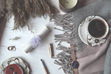 Atmosferik düz beyaz ahşap Resepsiyon wollen ekose, fincan kahve, kek, dekorasyon, mum ile yatıyordu. Hygge tarzı.