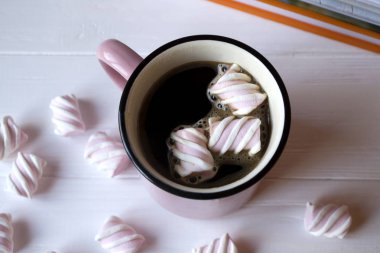 Pembe Beyaz ahşap bir masa üzerinde hatmi ile sıcak kahve fincan.