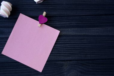 Pembe kağıt, kalem ve hatmi koyu mavi ahşap masa üzerinde yaprağı.