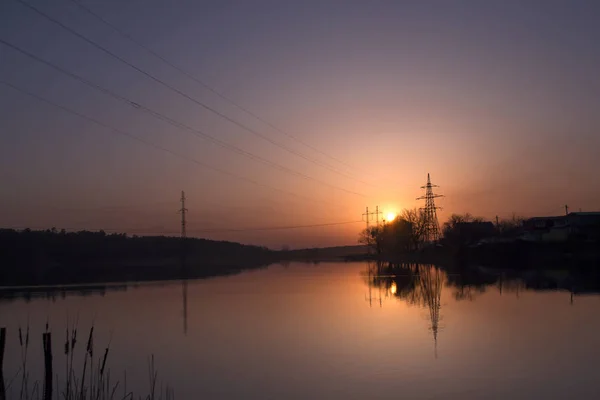 Sunset landscape. Pond at sunset time. Evening color of sky.