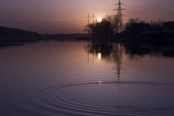 Sunset landscape. Pond at sunset time. Evening color of sky.