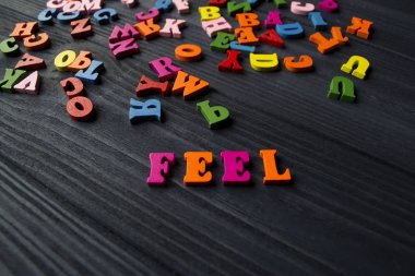 Koyu mavi ahşap arka plan çok renkli harfler. Bir tablo üzerinde renkli ahşap alfabe.