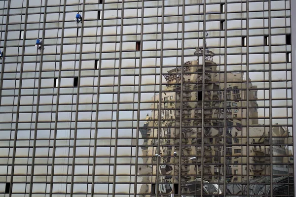 Distorted reflection of house in glass building.