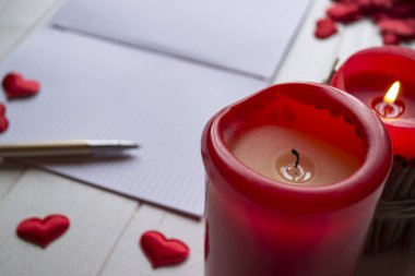Kırmızı mumlar, sevgi kalpleri ve defter masanın üzerinde. Kopya alanı ile güzel bckground.