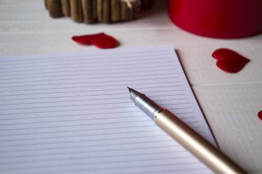 Bir tablo açılan not defteri ve sevgi kalpleri.
