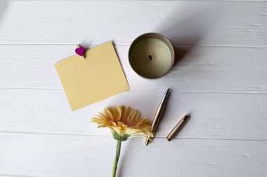 Beyaz ahşap zemin üzerinde boş kağıt ve Biege'e gerbera.