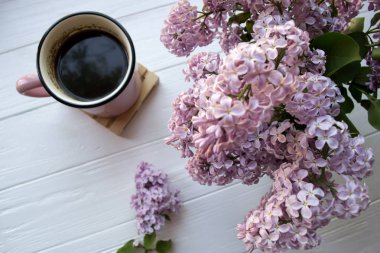 Bir fincan kahve ve Lila çiçek beyaz ahşap tablo.