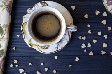 Bir fincan kahve ve tatlı bir koyu mavi ahşap tablo. Rustik tarzı.