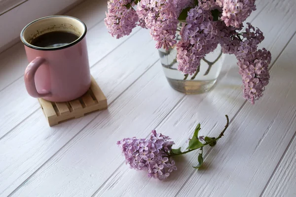 Ένα Φλιτζάνι Καφέ Και Λιλά Άνθη Λευκό Ξύλινο Τραπέζι — Φωτογραφία Αρχείου