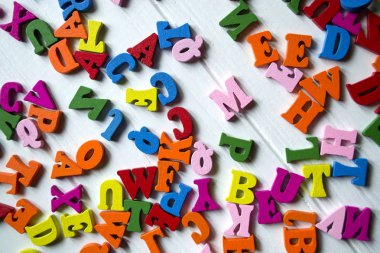 Çok renkli harfler Beyaz ahşap zemin üzerinde. Bir tablo üzerinde renkli ahşap alfabe.