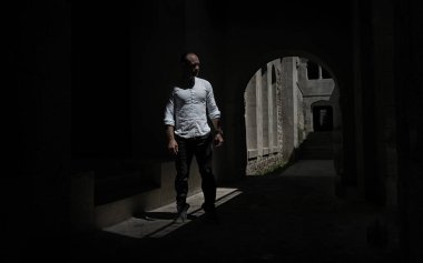 Man modeli Güneş gözlüğü ve eski Gürcü kale beyaz gömlek