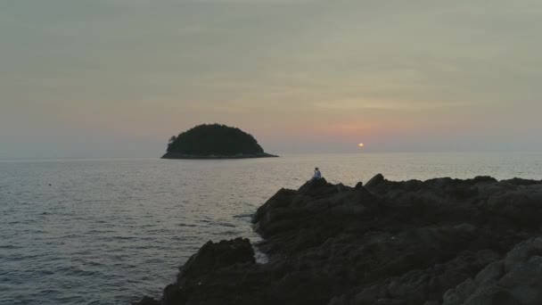 Człowiek w białym na zachód słońca plaża w skałach, Tajlandia — Wideo stockowe