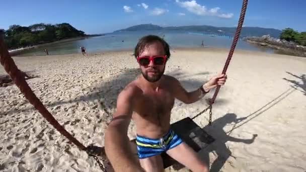 タイのビーチでスイングの男 selfie — ストック動画