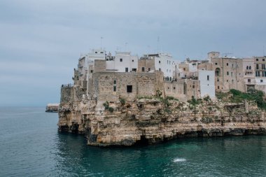 A Mare apulia İtalya Polignano kıyılarında kayaların üzerinde eski evler