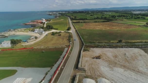 Auto rijden door het veld in de buurt van de zee in Italië Drone vlucht 4k — Stockvideo